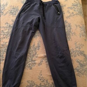 navy blue joggers. cuffed legs. back pocket and 2 front pockets w/ zippers